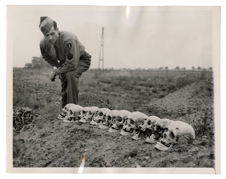 World War II Era News Photo, “Soldier Views Skulls.”