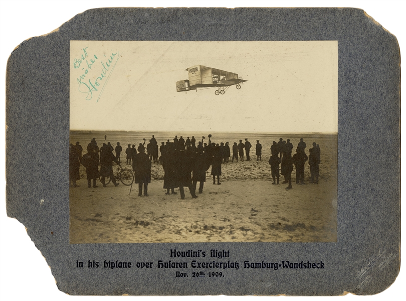  Houdini, Harry. Signed photograph of Houdini piloting his b...