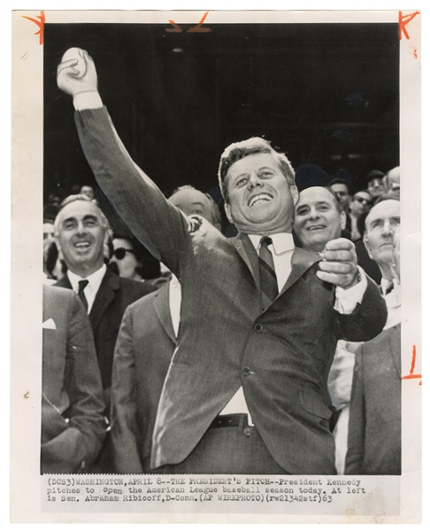  KENNEDY, John Fitzgerald. Press photo of JFK throwing first...