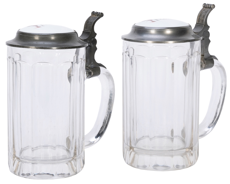  Two Faust Beer Steins. Two glass beer steins with porcelain...